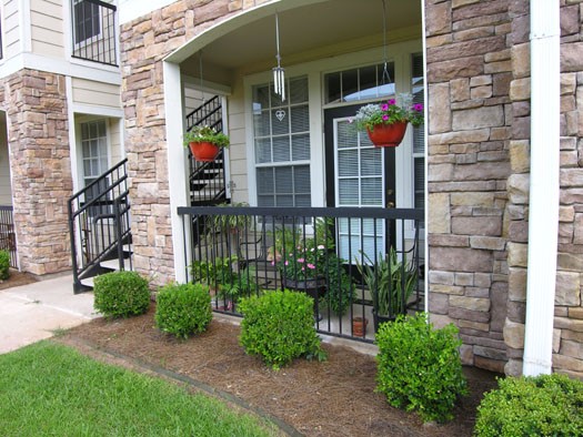 Riverwalk up close view of fenced porch and stairs leading up to second floor